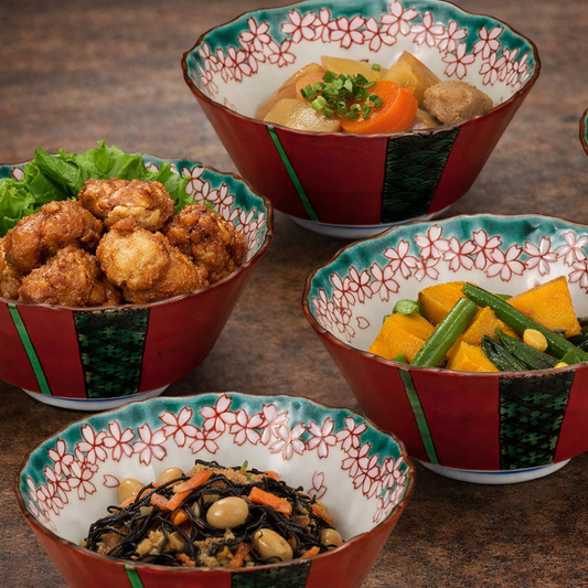 Four bowls with floral patterns containing various dishes on a wooden surface.